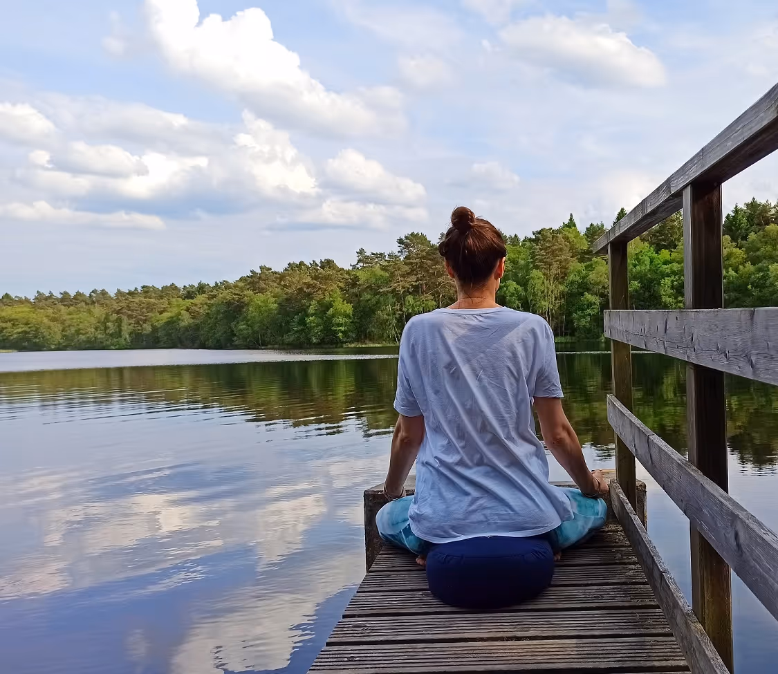 Meditation auf einem Steg am See
